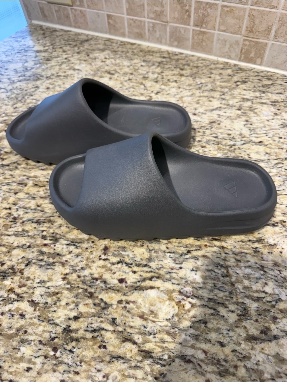 Graphite grey Yeezy slides.